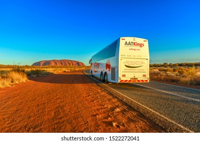 Uluru, Northern Territory, Australia - Aug 25, 2019: AAT Kings Tours And Activities Driving To Ayers Rock In Uluru-Kata Tjuta National Park At Sunset.AAT Kings Is An Australia S Guided Holiday Company