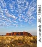 Uluru at sunrise with textured clouds in the sky