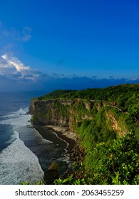 Uluwatu cliff view in the evening with rippling beach and blue sky on the island of Bali, Indonesia