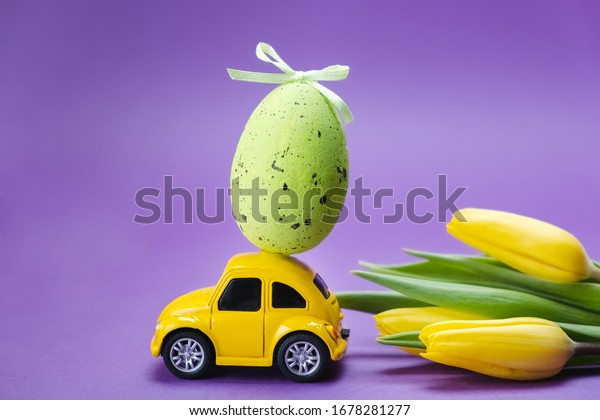 Ulyanovsk, Russia -\
March 2020: Easter holiday. Yellow retro car with an Easter egg on\
the roof. Easter\
card