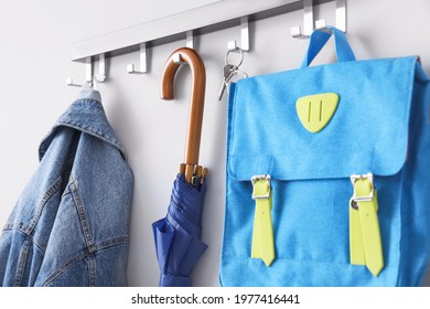 Umbrella With Clothes And School Backpack Hanging On Wall In Hall