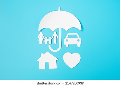 Umbrella Cover Family, Home And Car Shape Paper On Blue Background. International Day Of Families, Healthcare, Wellness And Insurance Concept