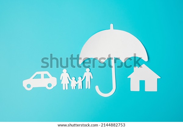 Umbrella cover family, home and Car shape paper\
on blue background. International day of families, Healthcare,\
wellness and Insurance\
concept