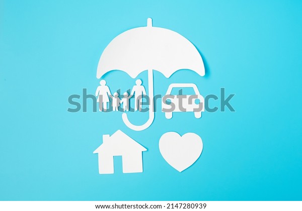 Umbrella cover family, home and Car shape paper\
on blue background. International day of families, Healthcare,\
wellness and Insurance\
concept