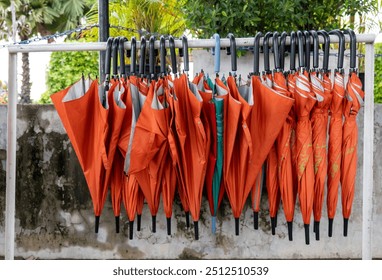 Umbrella hang on rack, Rainy season concept, Umbrellas prepared for tourism, Orange Umbrella hang on rack.  - Powered by Shutterstock