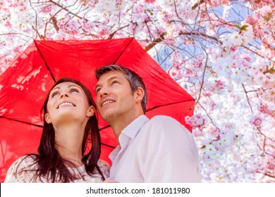 umbrella safety younger couple smiling - Powered by Shutterstock