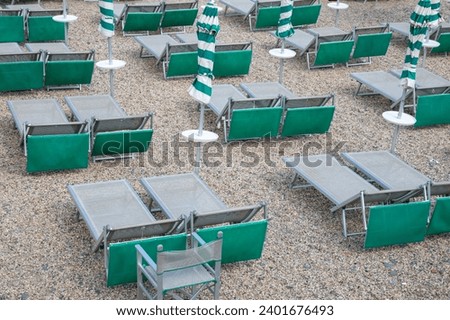 Umbrellas green white and seats grey in a private beach coast
