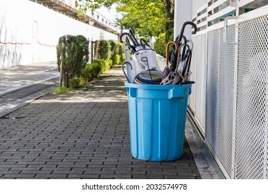 
Umbrellas No Longer Needed In A Blue Bucket