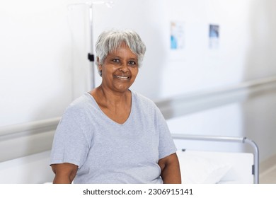 Unaltered portrait of happy senior biracial female patient on hospital bed smiling, with copy space. Friendly, hospital, medical and healthcare services. - Powered by Shutterstock