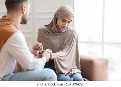 Unanswered Love. Unhappy Muslim Woman Saying No To Marriage Proposal Of Her Boyfriend, Holding Hands Sitting On Sofa At Home. Relationship Problem, Forced Marriage Concept. Selective Focus - Shutterstock ID 1875834298