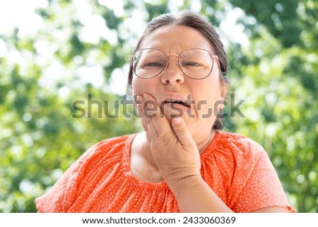 unbearable tooth pain, middle-aged caucasian woman holds on to jaw, close up female face with facial expression suffering, excruciating dental pain, dental nerve inflammation