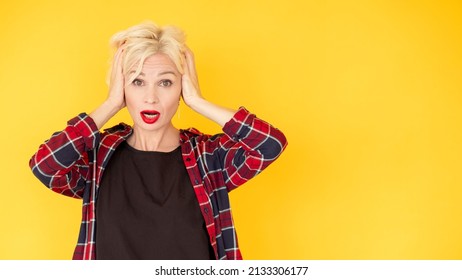 Unbelievable expression. Confused woman. Shocked situation. Disbelief emotional middle-aged lady grasping head with hands isolated yellow copy space.