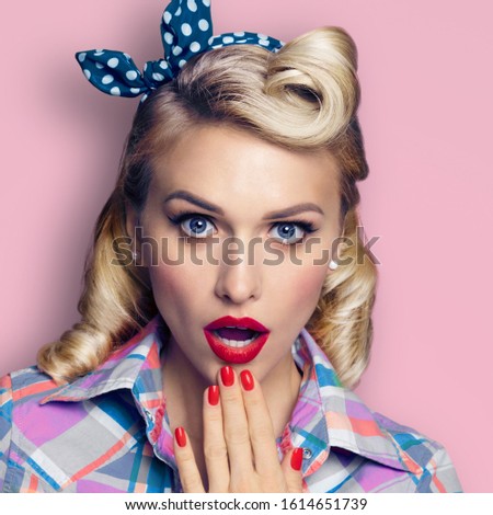 Unbelievable news! Excited surprised blond woman. Pin up girl with open mouth. Retro and vintage concept picture. Pink background. Square composition. 