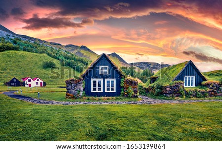 Unbelievable sunrise in icelandic countryside. Typical view of turf-top houses in Iceland. Gorgeous summer view of Skogar village, south Iceland, Europe. Traveling concept background.