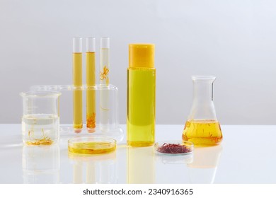Unbranded bottle filled with liquid and arranged with laboratory glassware over white background. Saffron is the most expensive spice in the world - Shutterstock ID 2340916365