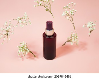 Unbranded Brown Cosmetic Spray Bottle And Flying Gypsophila Flowers On Pink Background. Natural Organic Spa Cosmetics. Body Mist, Mockup, Template.