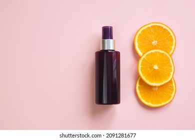 Unbranded Brown Cosmetic Spray Bottle And Orange Slices On Pink Background. Natural Organic Spa Cosmetics. Body Mist Oil. Cream Tube With Vitamin C. Mockup, Template.