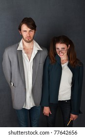 Uncomfortable Nerd Man And Woman Couple On Gray Background