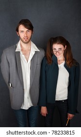 Uncomfortable Nerd Man And Woman Couple On Gray Background