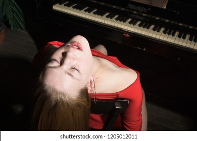 Unconcsious beauty woman in evening dress at the piano