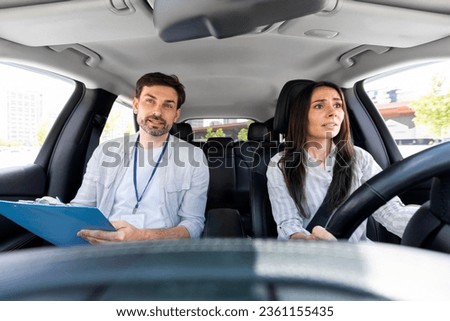 Unconfident millennial pretty woman driving car for first time with instructor handsome man giving her advices and tip. fear of driving concept. Scared lady attending driving school