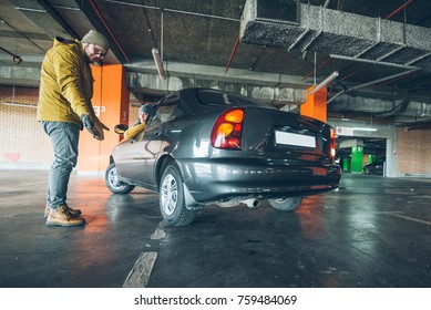 Unconfident Young Woman Parking Car On Empty Spot In Underground Parking With Man Help