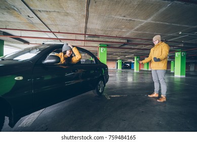 Unconfident Young Woman Parking Car On Empty Spot In Underground Parking With Man Help