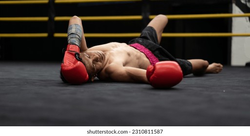 Unconscious Asian boxer lay on floor referee counting down knockout in the ring at fitness gym. Boxing is fighter sport training need body muscular strength, power fist and sweating to become champion - Powered by Shutterstock