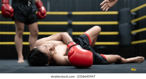 Unconscious Asian boxer lay on floor referee counting down knockout in the ring at fitness gym. Boxing is fighter sport training need body muscular strength, power fist and sweating to become champion - Powered by Shutterstock