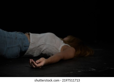 Unconscious Or Dead Woman Body Lying On Floor At Crime Scene In Dark Room. Murder, Kill And Rape People Concept