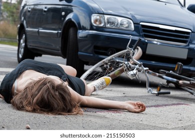 Unconscious Female Cyclist Lying On Street After Road Accident