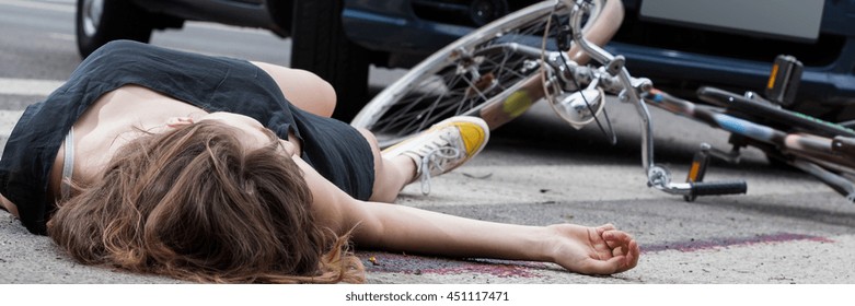 Unconscious Female Cyclist Lying On Street After Road Accident