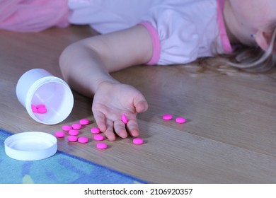 Unconscious little child (girl) with pink pills on the floor at home. Danger of medicament intoxication.