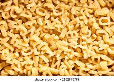 Uncooked Alphabet Soup Pasta Letters Background. Concepts: Healthy Mediterranean Food, Carbohydrates Diet, Fun Education.