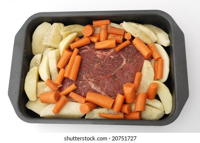 An Uncooked Beef Chuck Pot Roast In Pan With Potatoes And Carrots.