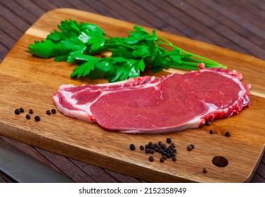 uncooked beef marbled steak served with pepper and parley on the table - Shutterstock ID 2152358949