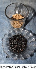 Uncooked black beans, soy bean seeds ( Urad dal, black gram, vigna mungo ) in a glass bowl, ingredients for making sweet soy sauce,