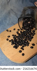Uncooked black beans, soy bean seeds ( Urad dal, black gram, vigna mungo ) in a glass bowl, ingredients for making sweet soy sauce,