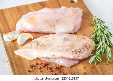 Uncooked chicken breast on the cutting board - Shutterstock ID 2234815157