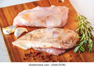 Uncooked chicken breast on the cutting board - Shutterstock ID 2244170781