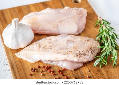 Uncooked chicken breast on the cutting board - Shutterstock ID 2260762753