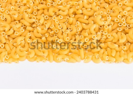 Uncooked Chifferi Rigati Pasta Scattered on White Table. Fat and Unhealthy Food. Classic Dry Macaroni. Italian Culture and Cuisine. Raw Pasta