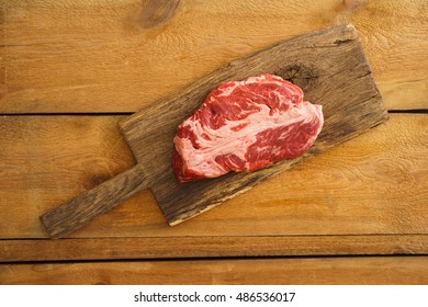 Uncooked Chuck Eye Steak On Wooden Board