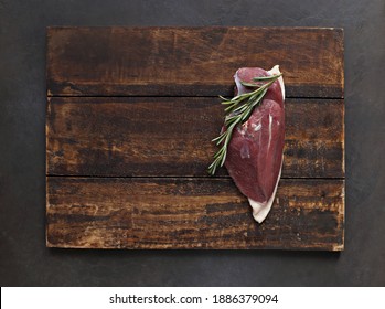 Uncooked Duck Breast With Herbs And Spices On A Dark Wooden Cutting Board. Overhead View. Copy Space