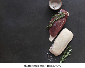 Uncooked Duck Breast With Herbs And Spices On A Dark Wooden Cutting Board. Overhead View. Copy Space