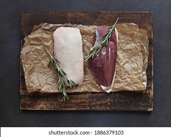 Uncooked Duck Breast With Herbs And Spices On A Dark Wooden Cutting Board. Overhead View. Copy Space