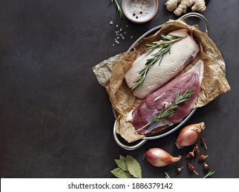 Uncooked Duck Breast With Herbs And Spices On A Dark Wooden Cutting Board. Overhead View. Copy Space