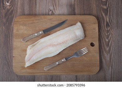 Uncooked Fish Filet , Knife And Fork On The Oak Board, Top View