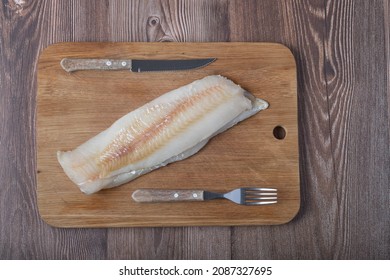 Uncooked Fish Filet , Knife And Fork On The Oak Board, Top View