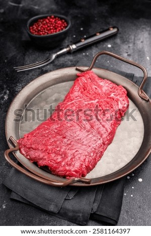 Uncooked flank steak, raw beef flap meat steak. black background. top view.